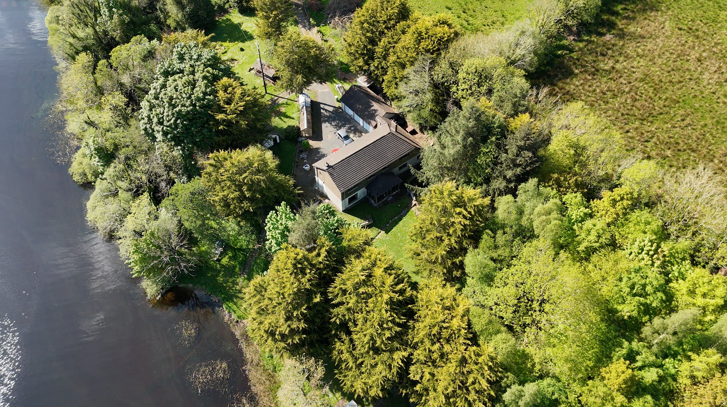 Overhead view of the existing residence, surrounding trees and lakeshore